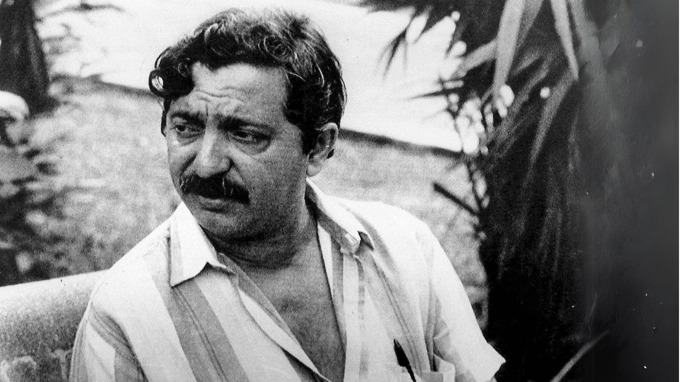 Foto hitam putih Chico Mendes berkumis mengenakan kemeja putih